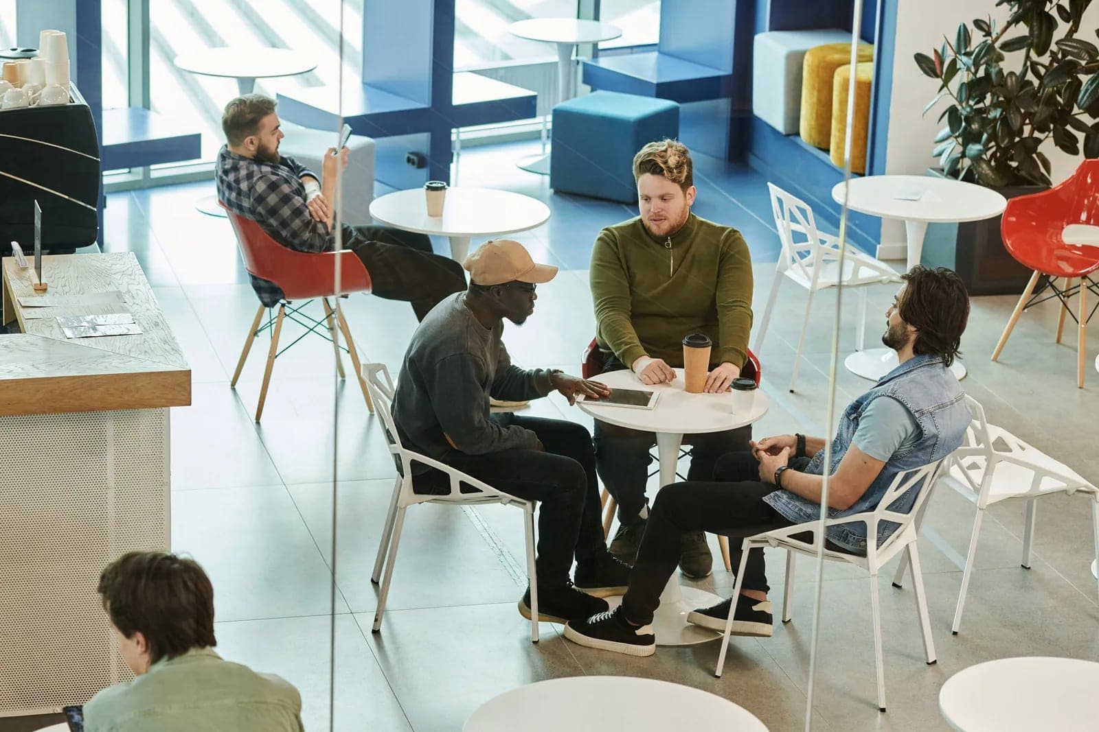 Colleagues talking together around a table in a shared workspace