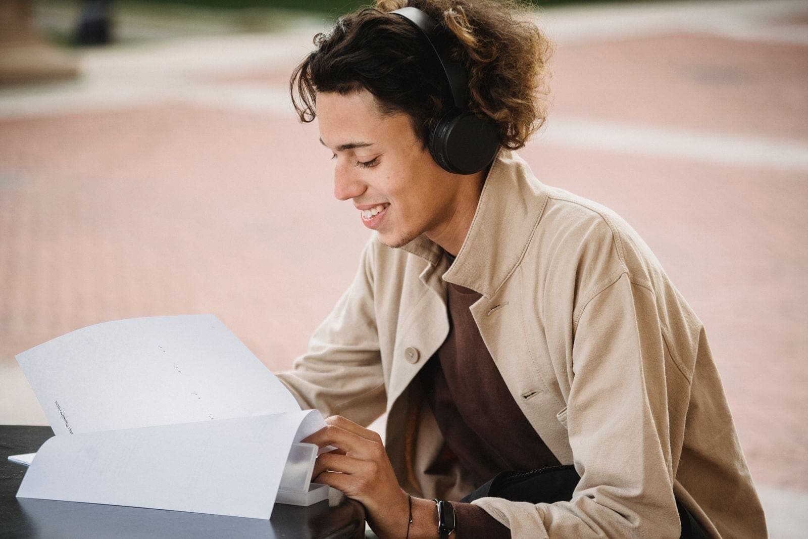 A smiling learner holding printed study materials