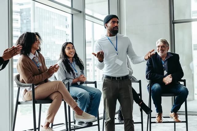 A man explaining an idea to a small group during a workplace session