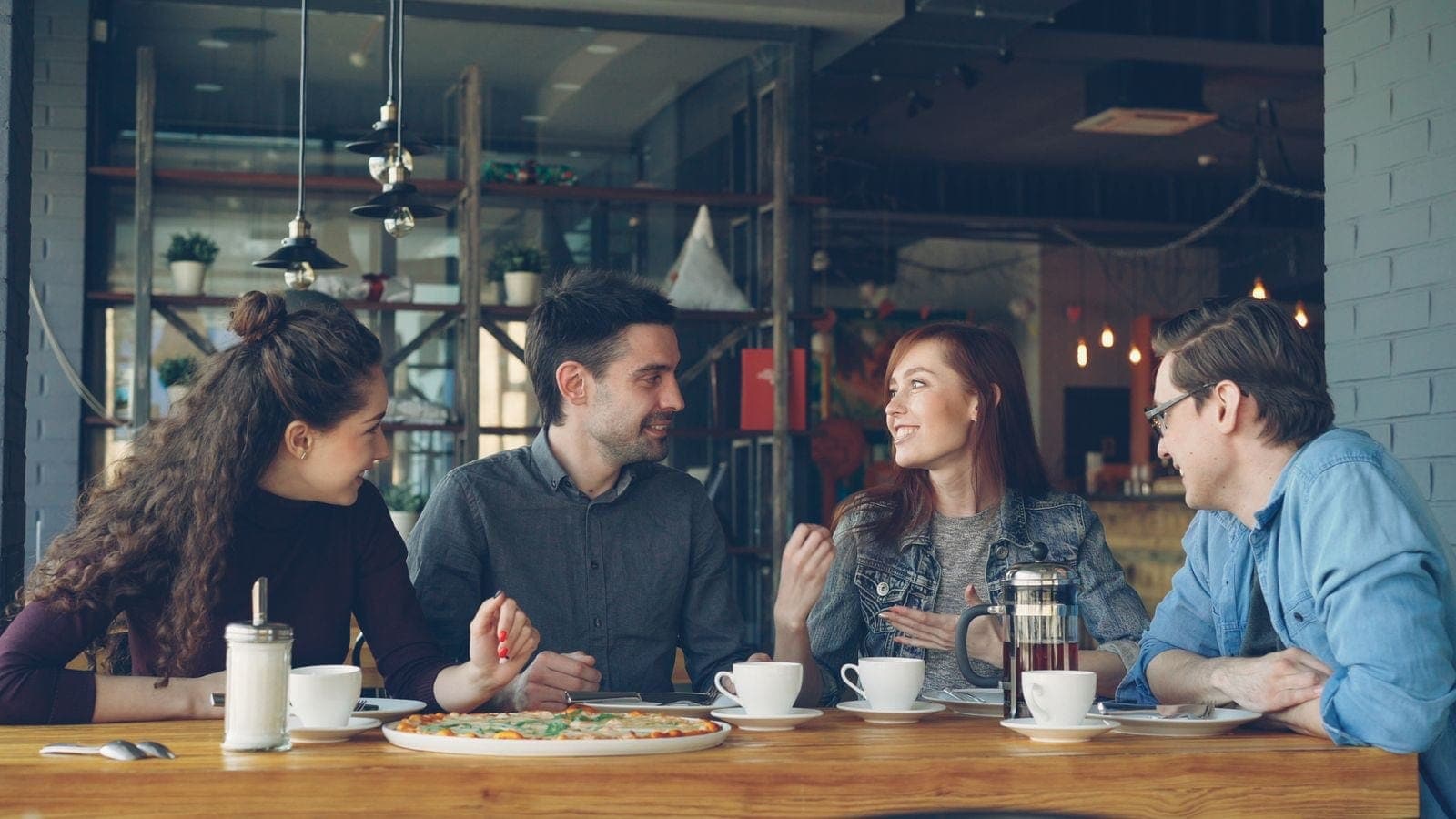 Friends Enjoying Coffee and Conversing at a Cafe
